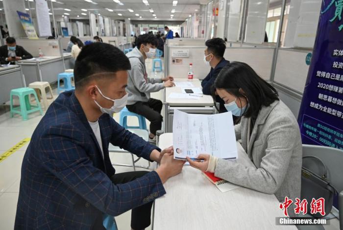 4月14日，招聘者在查看求職者簡歷。<a target='_blank'  data-cke-saved- >中新社</a>記者 王剛 攝