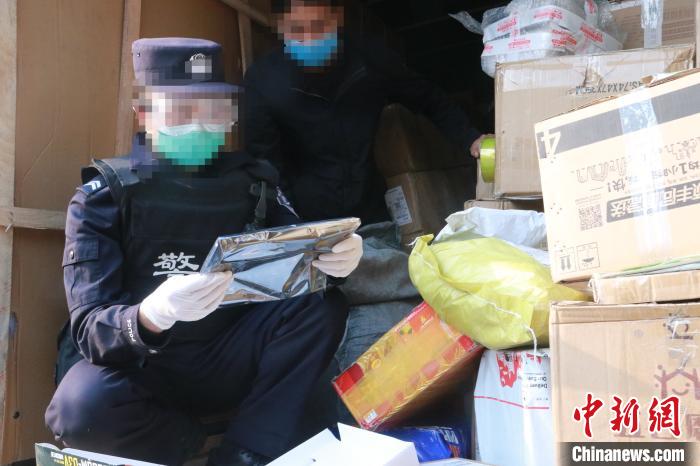 圖為勐康邊檢站民警在對(duì)快遞運(yùn)輸車輛進(jìn)行例行檢查?！钐?攝