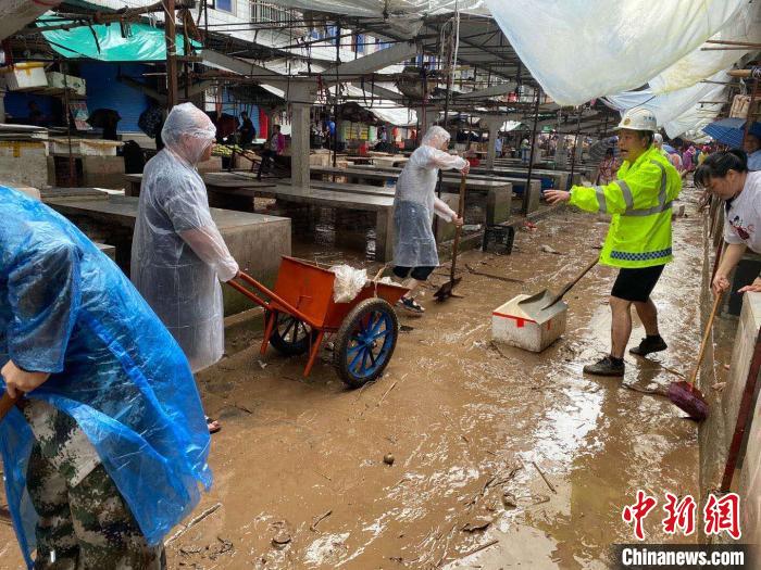 圖為7月26日，暴雨引發(fā)的洪水過境后，重慶萬州區(qū)分水鎮(zhèn)政府干部職工及志愿者清掃淤泥和垃圾?！　≈貞c萬州區(qū)委宣傳部供圖 攝