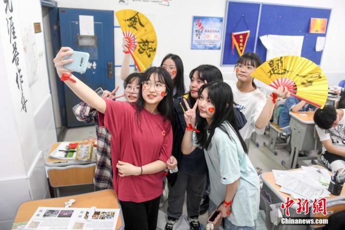 資料圖：6月6日，2021年高考前夕，湖南長沙同升湖實驗學(xué)校高三年級，考生們在教室內(nèi)合影。 楊華峰 攝